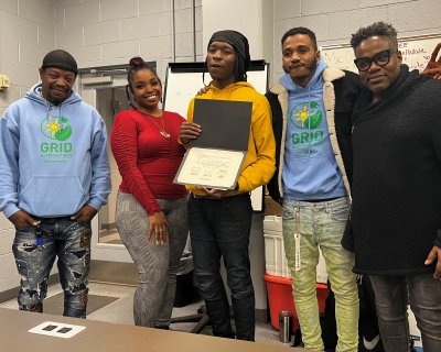Khalil holds his certificate after graduating from the Solar Works DC program.