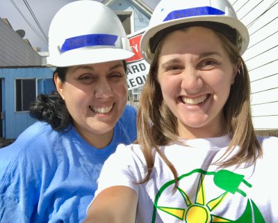 Dolores Garay and Lauren Morgan take a selfie while wearing hard hats at a GRID install