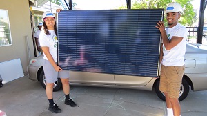 Volunteers pose holding a solar panel