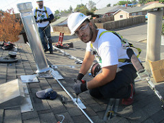 Portrait of a trainee working with conduit on the roof