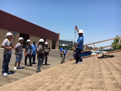 Trainees watch instructor on GRID Central Valley's mock roof