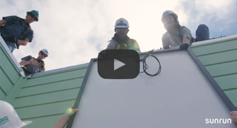 Sunrun employees pull a solar panel up on a roof in a screenshot from our partnership video