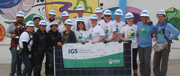 La Hacienda orphanage staff, GRID installers, and trainees hold a GRID/IGS banner in front of the orphanage