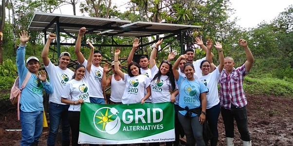 GRID installers and community participants celebrate in front of their ground mount system in Zanzibar
