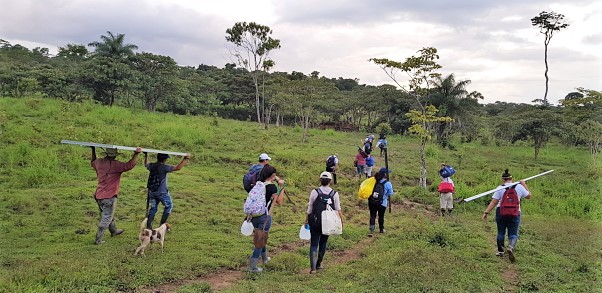 GRID staff and community participants carry racking through a field