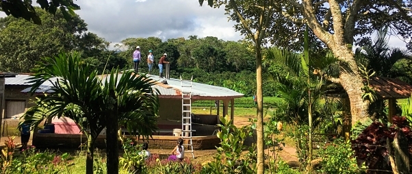 Surrounded by trees, installing solar on a modest home in rural Nicaragua