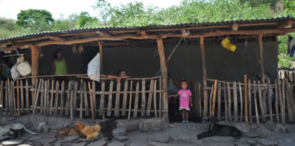 Village home in Nicaragua with a child in a pink dress in the doorway