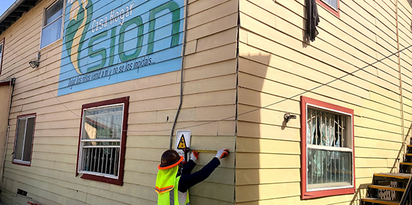 Installing solar on the Sion building, showing the mural painted there