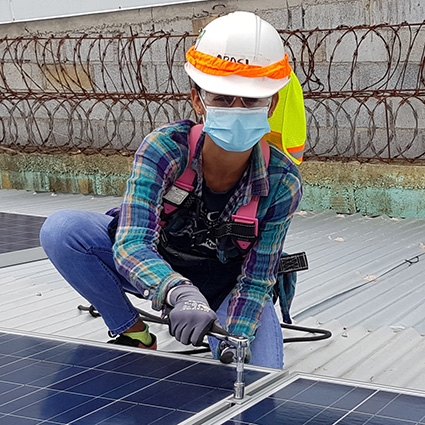 Arasi kneels to install a panel