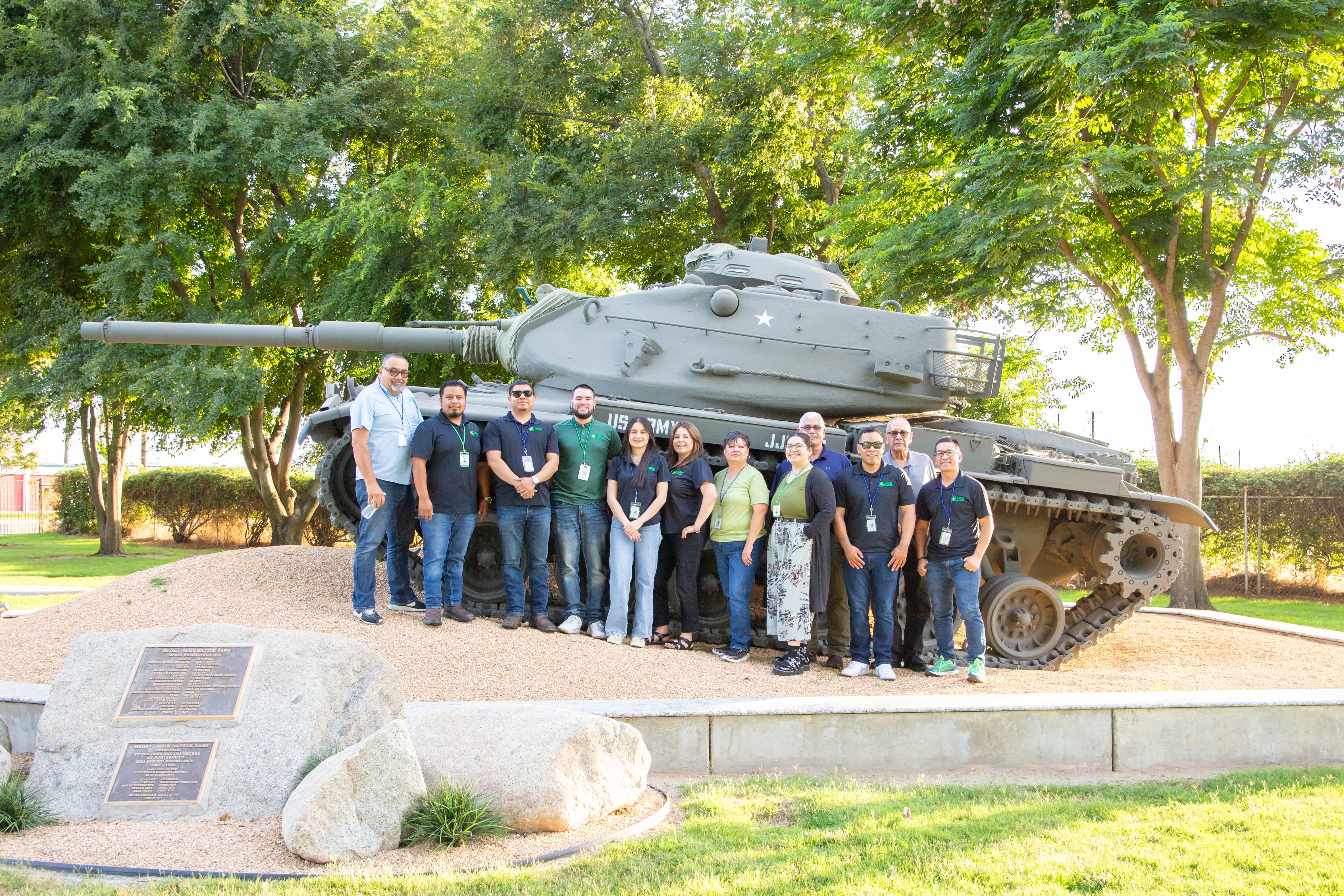 GRID Outreach Staff posing for a picture in front of retired army Tank