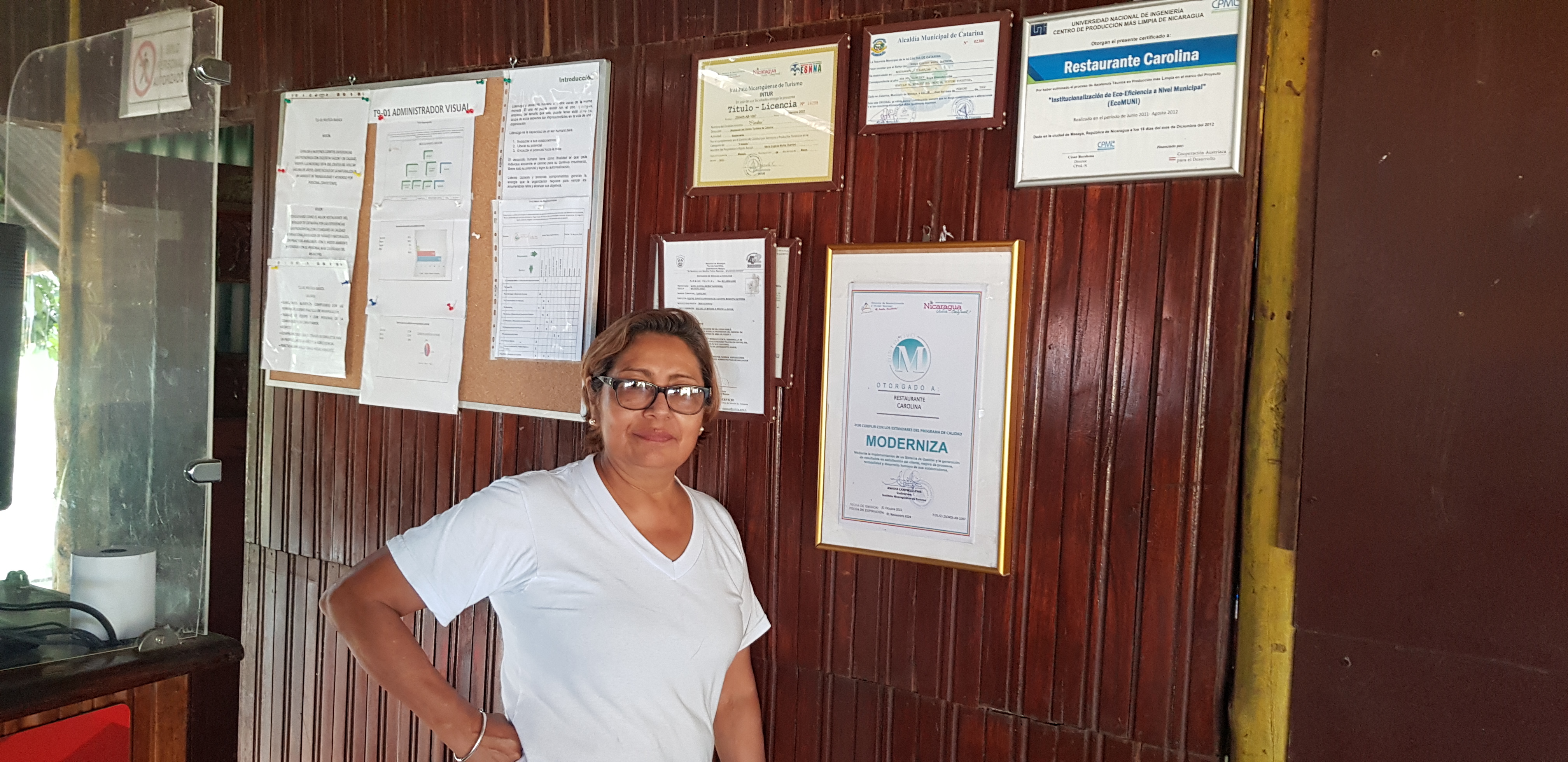 Maria Eugenia in front of restaurant wall