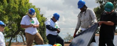 Grid staff and volunteers working on mounting solar panels
