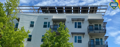 Photo of Lavender Courtyard LGBTQIA+ Senior Housing Center in Sacramento, CA with solar array on rooftop. A graphic saying "Happy Pride" overlays photo in upper right corner. 