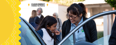 Clean energy powers the people: a woman and child smile at an EV event in Richmond