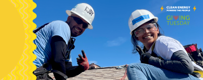 GRID staffer and trainee smile from the roof to celebrate Giving Tuesday