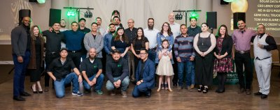 Large group photo of staff members posing of a picture from a banquet