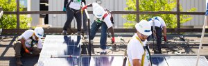 a group of men installing solar on a mock roof