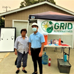 Ms. Gallegos and GRID staff in front of her home