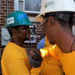 Solar Works DC trainees celebrate finishing groundwork at an install.