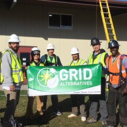 GRID Alternatives Bay Area's North Coast Office Solar Installation Supervisor is posing with Pinoville Pomo Nation Members at an installation of a photovoltaic system in the Nation's community gym