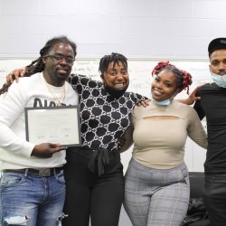 Dante (left) holds his Solar Works DC graduation certificate along with the GRID Mid-Atlantic workforce training staff