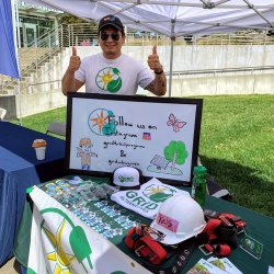 Jose Valverde, Bay Area-North Coast Community Engagement trainee is posing holding his two thumbs up for a picture at a community event in Willits, CA