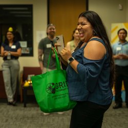 Sophia from Rising Sun Center for Opportunity smiling after winning a green GRID swag bag in a raffle.