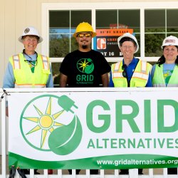Dry Creek Rancheria Band of Pomo Indians member at center surrounded by GRID Alternatives North Coast team members, Cora Saxton, regional director and Kelsey Radmilovich, outreach manager 