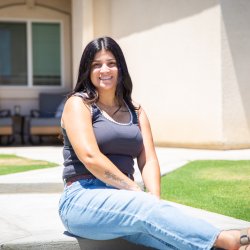 Woman sitting down in front of her home