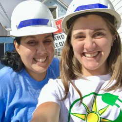 Dolores Garay and Lauren Morgan take a selfie while wearing hard hats at a GRID install