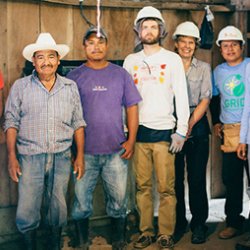 People in hard hats smile on construction site in Nicaragua