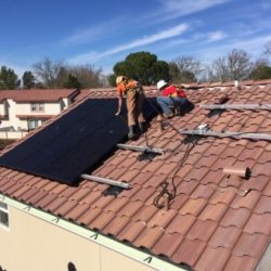 Community members install rooftop solar on the Rolling Hills apartment complex.