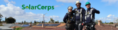 3 people smiling on the roof with the solarcorps logo