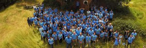 Aerial photo of GRID staff, all in blue GRID t-shirts, on a green lawn