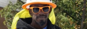 Portrait of a smiling young man in hard hat and sunglasses