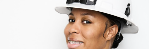 Image of black woman in a white hard hat against a white background 