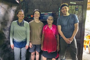 A solar home system beneficiary and three of the travelers