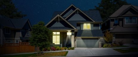 A suburban home lit up at night