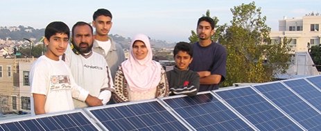 Family of clients gathered around their solar panels