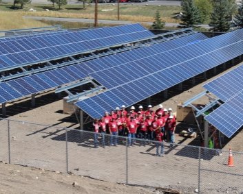 An enormous community solar field with a group of Wells Fargo volunteers in front