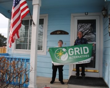 The Comptons hold a GRID banner in front of their home