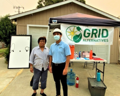 Ms. Gallegos and GRID staff in front of her home