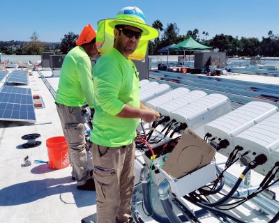 Man in a hard hat and bright green shirt on a roof construction site