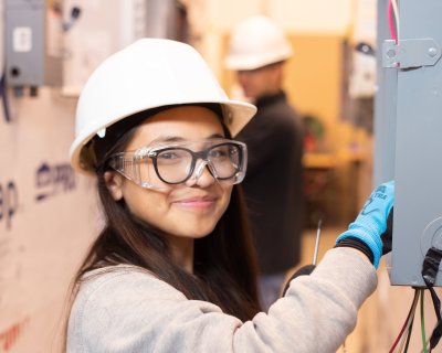 solar futures student leaning to wire main servie panel