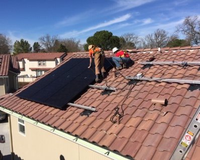 Community members install rooftop solar on the Rolling Hills apartment complex.