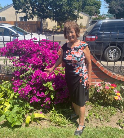 Pauline showing off her gardening skills with the bougainvillea in her front yard.