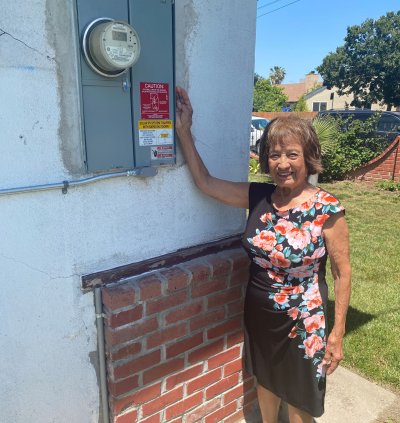 Pauline standing next to her new main service panel.