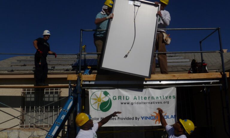 Workers installing solar panels on a rooftop for GRID Alternatives, an environmental organization promoting renewable energy