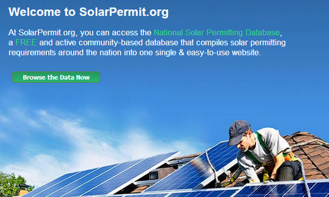 Worker installing solar panels on residential rooftop under blue sky