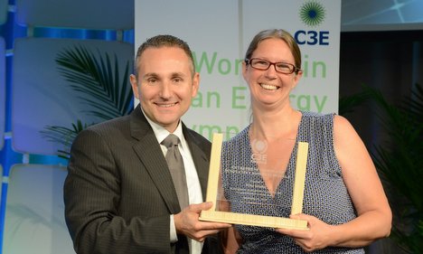 Man and woman holding award at C3E women in clean energy event